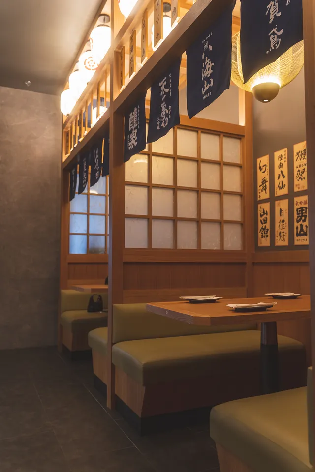 Genki’s booths beneath wooden menu plaques and indigo noren