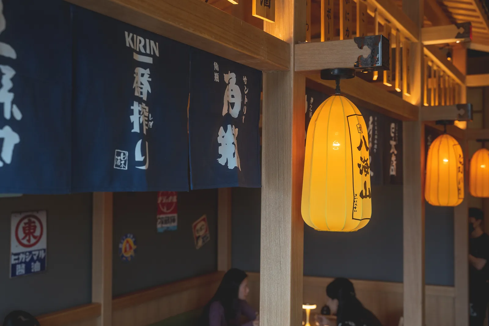 Warm lanterns and indigo noren curtains inside Genki Izakaya